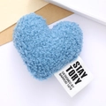 Close-up of blue plush heart accessory with soft faux shearling texture and woven label - Blue