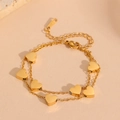 Detailed view of double-layer gold plated stainless steel bracelet with heart charms - Gold