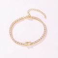 Detailed macro shot of a gold tennis bracelet featuring a central emerald-cut zircon - Rectangular Style (Clear Rhinestone) / Gold