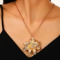 Gold flower pendant necklace with central gemstone worn by a model on a black top - Gold Rhinestone Flower Necklace (Z-068)
