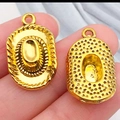 Goldener Cowboyhut-Anhänger auf dem Finger gezeigt, um die kleine Zubehörgröße zu betonen - Antik Gold Cowboyhut (23x13mm)