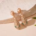 Dettaglio orecchini a serpente dorati con perle finte e gemme verdi scintillanti - Orecchini a serpente con strass dagli occhi verdi con perno in argento