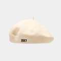 Detailed close-up of the 1987 embroidery on a cream wool blend beret hat for women - One Size(Adjustable) / Beige