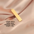 Colgante rectangular dorado pulido 30x6mm sobre satén rosa con medidas del producto - Dorado