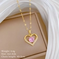 Detailansicht eines goldenen Herzanhängers mit rosa Edelstein und Kristallverzierung - Rosa (H232)