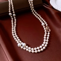 Close-up of double-layer pearl necklace with zircon accents on red silk background - Gold-White