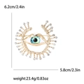 Gold evil eye brooch with crystals, size 6.2x5.8cm, weighing 23.4g on white background - Gold