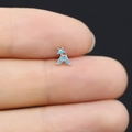 Macro view of a tiny silver stud earring with turquoise stones on a fingertip - Turquoise Bow