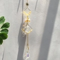 Gros plan d'un attrape-soleil doré avec éclats d'améthyste et prisme en cristal facetté - Citrine