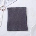 Dark grey knitted cashmere neck warmer shown flat in a stylish lifestyle setting - Dark Gray