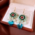 Close-up of handmade beaded flower earrings with a blue heart crystal in a gift box - Blue Hook Style