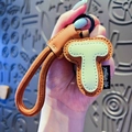 Creative faux leather letter T keychain with brown litchi pattern and woven green strap - Letter T
