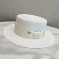 Primer plano de sombrero canotier blanco con cinta de seda y logo metálico M dorado - Ajustable / Blanco