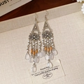 Close-up of vintage floral earrings with silver metal hollow carving and beaded tassels - Vintage White Flower Glass Teardrop Tassel Ear Hooks