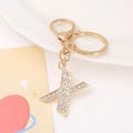 Detail view of a gold-tone letter X keychain featuring sparkling crystal rhinestones - Letter X
