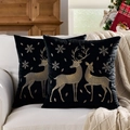 Pair of black cushion covers with gold deer and snowflake embroidery on a sofa - Embroidered Gold Reindeer Black Base/Black