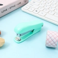 Mini agrafeuse portable vert menthe sur un bureau propre avec accessoires de style - Agrafeuse Vert Menthe