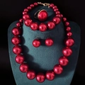 Elegant red faux pearl jewelry set with necklace and earrings on green velvet stand - Dark Red