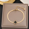 Macro detail of gold snake chain bracelet with black clover charm and heart pendant - 589 Gold Black Four-Leaf Clover (589 Gold)
