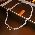 Vue détaillée du fermoir CD entrelacé plaqué or 18k serti de cristaux sur perles - Collier Nez De Porc Perle Zircon