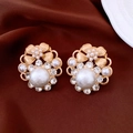 Détail des boucles d'oreilles vintage avec perles et cristaux sur un tissu soyeux - Clip d'oreille - Or