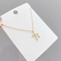 Macro detail of gold double cross necklace featuring micro-pave cubic zirconia on white card - Gold