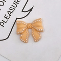 Accessorio fiocco arancione caramella con perle bianche per decorare custodie - Giallo