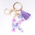 Detail of letter K crystal resin keychain with purple tassels and crushed stone infill - Letter K
