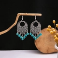 Detailed close-up of bohemian hollow silver earrings with turquoise beads on a rustic branch - E3058-2/Retro Carved Turquoise Drop