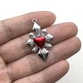 Pendente stella gotica con cuore rosso mostrato su una mano con sfondo bianco neutro - Cuore Rosso Croce Raggi di Sole