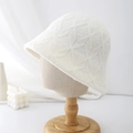 Detail of white plush bucket hat featuring a textured diamond lattice pattern and soft fur - White