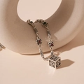 Detail of silver hollow cube necklace with floral cross engraving and gemstones - Silver Pattern Cube Necklace