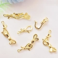 Gouden strikvormige sieraden sluitingen voor DIY kettingen op stoffen ondergrond - Universele Connector / 18K Goud