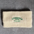 Detail of cream knit headband featuring ribbed texture and green Stockholm embroidery - Off White