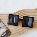 Fashionable square black resin sunglasses with dark lenses on a wave wood board - Black