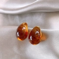 Detalle macro de los pendientes ovalados de ámbar chapados en oro 14K sobre seda - Gota de Agua Café (Aguja de Plata)