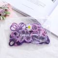 Macro shot of purple elastic hair bands in a daisy zipper bag on a cozy white desk - 50Pcs/Bag / Purple Series