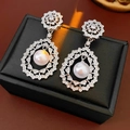 Detail of silver filigree earrings with sparkling cubic zirconia and white pearls on a box - Silver