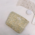 Detailed close-up of yellow floral cotton makeup bag with simple wish label and zipper - Creamy Yellow Floral