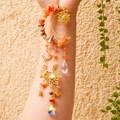 Detail of moon suncatcher with orange crystals, stars, and golden moon pendant - Red Agate
