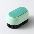 Handheld laundry cleaning brush with soft black bristles and a light green plastic body - Laundry Brush / Green