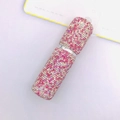 Macro van roze en witte steentjes op een 10ml navulbare parfumverstuiver voor reizen - Roze