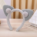 Dettaglio della fascia con orecchie da gatto in peluche grigio e pompon morbidi - Grigio