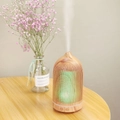 Detail of hollow wood grain humidifier with green LED light on wooden table - 200ml / Light Wood Grain