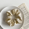 Elegant champagne satin scrunchie with pleated texture on a minimalist white plate - 1076B Champagne Milk Tea Satin Scrunchie