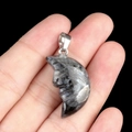 Labradorite carved moon face pendant with blue flash and metal bail on dark background - Larvikite