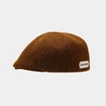 Close-up of brown wool beret featuring a rectangular side label on a gray background - One Size / Caramel color
