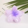 Close-up of a purple gradient frangipani flower hair claw clip on a ceramic tray - Purple Flower