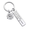Macro view of sunflower charm and engraved stainless steel tag on a silver keychain - Stand tall and find the sunlight