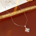 Macro di una collana con ciondolo a fiore in argento e zirconi su uno sfondo stile vintage - Collana (Collana-Oro Caffè)
